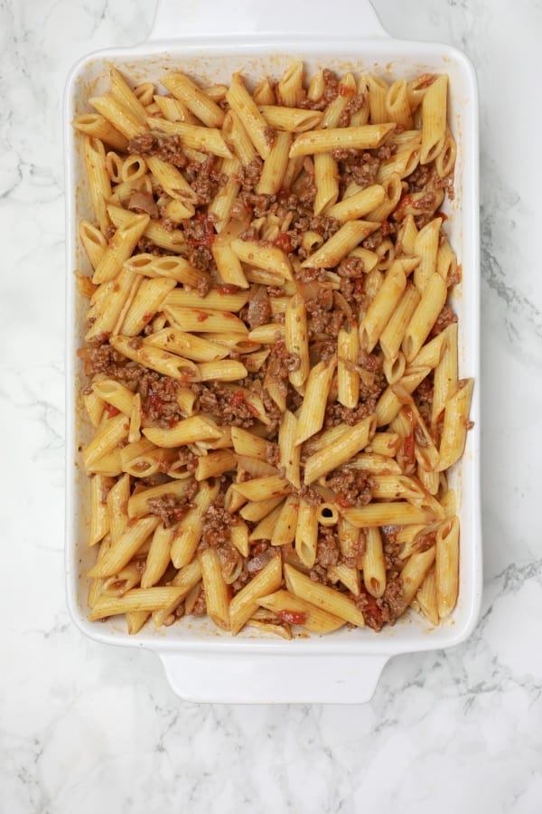 the minced beef sauce and pasta mixed in a baking dish.