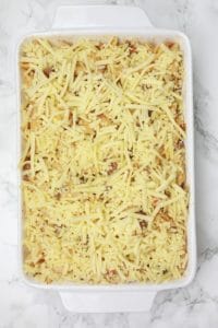 the mince and pasta topped with grated cheese in a baking dish.
