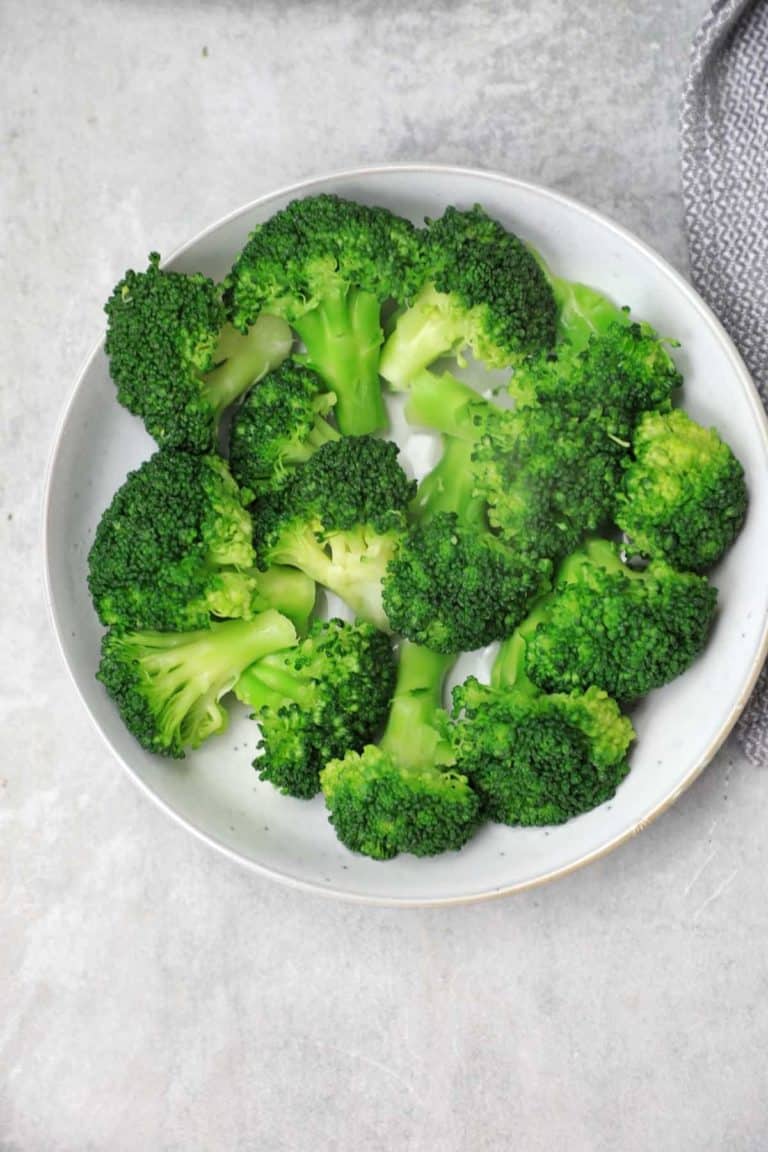 boiled broccoli served on a light blue plate.