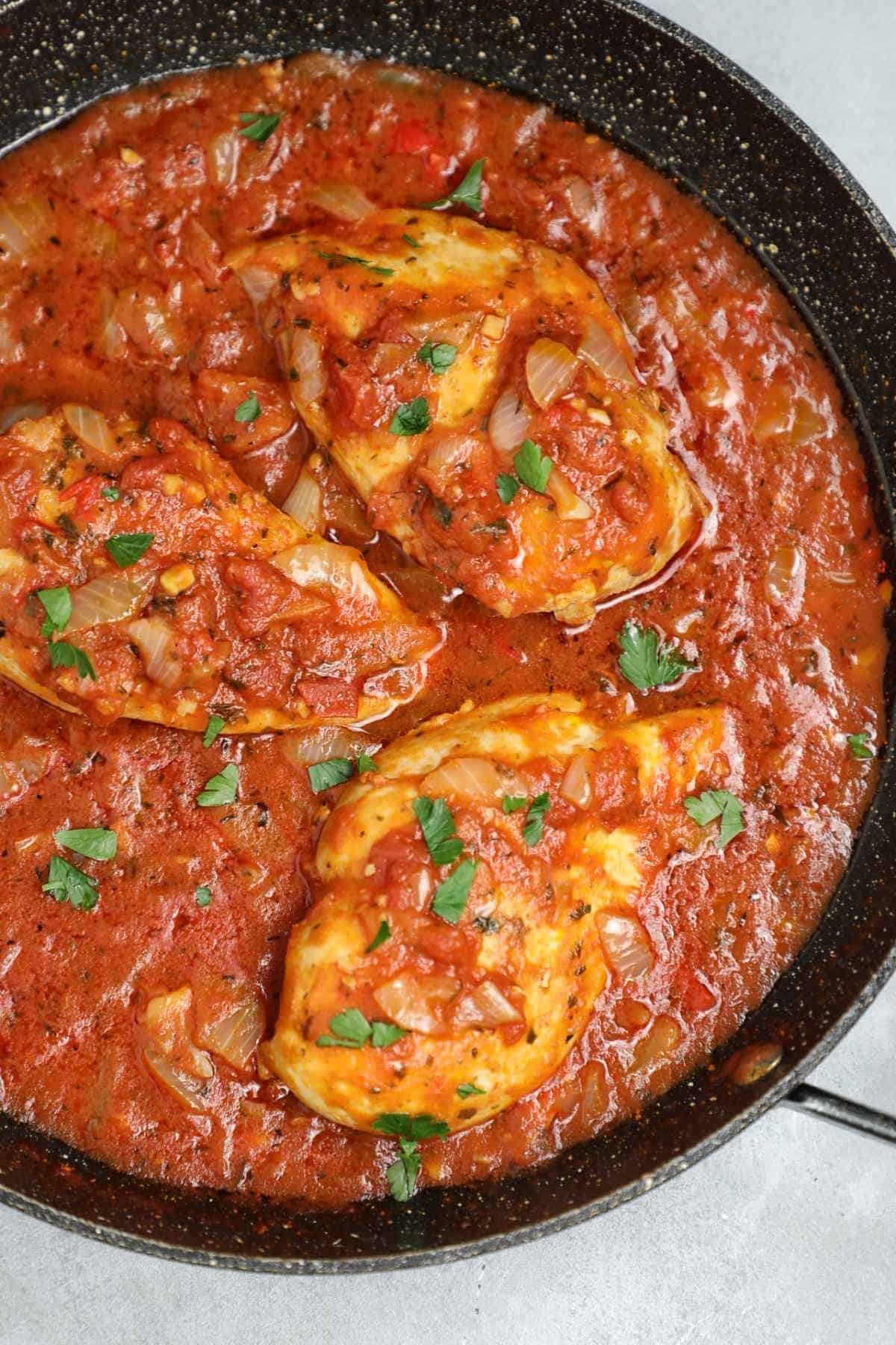the cooked chicken in tomato sauce in a skillet.