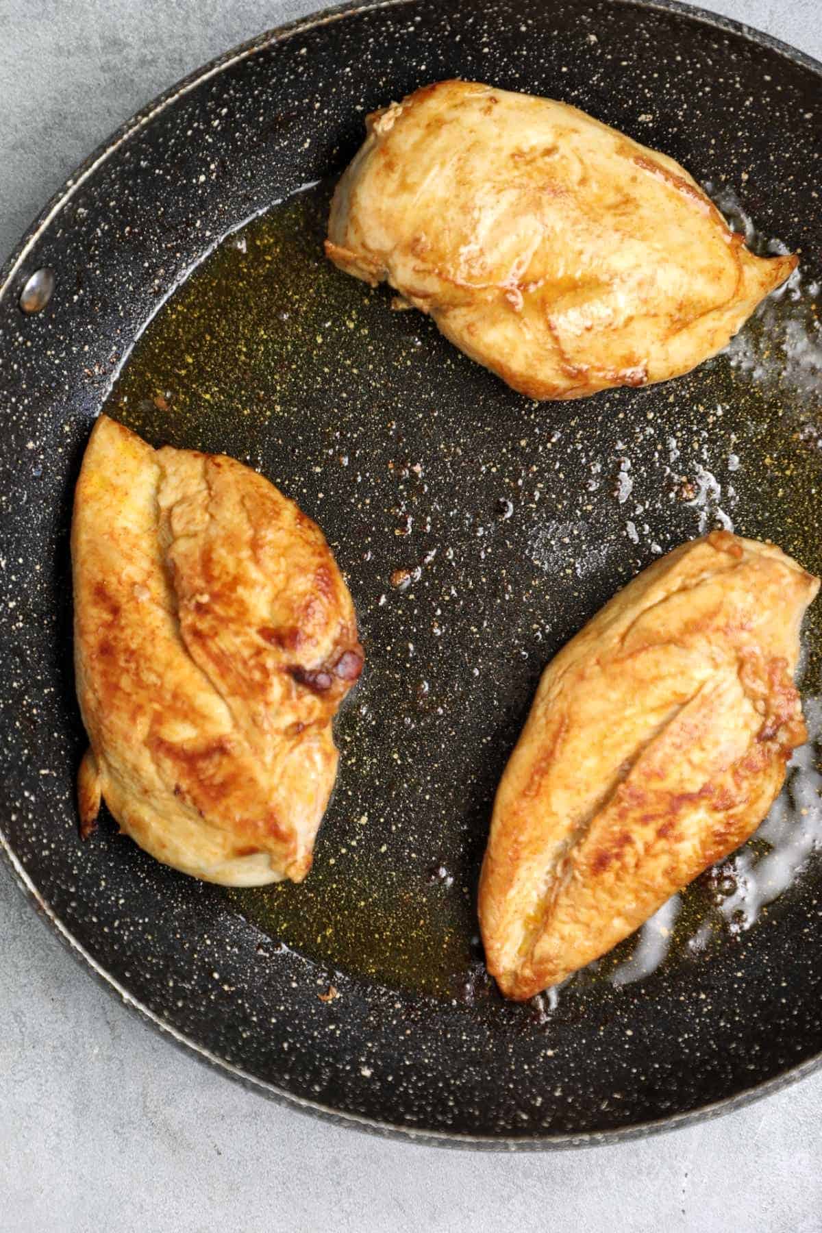 3 chicken breasts in a skillet.