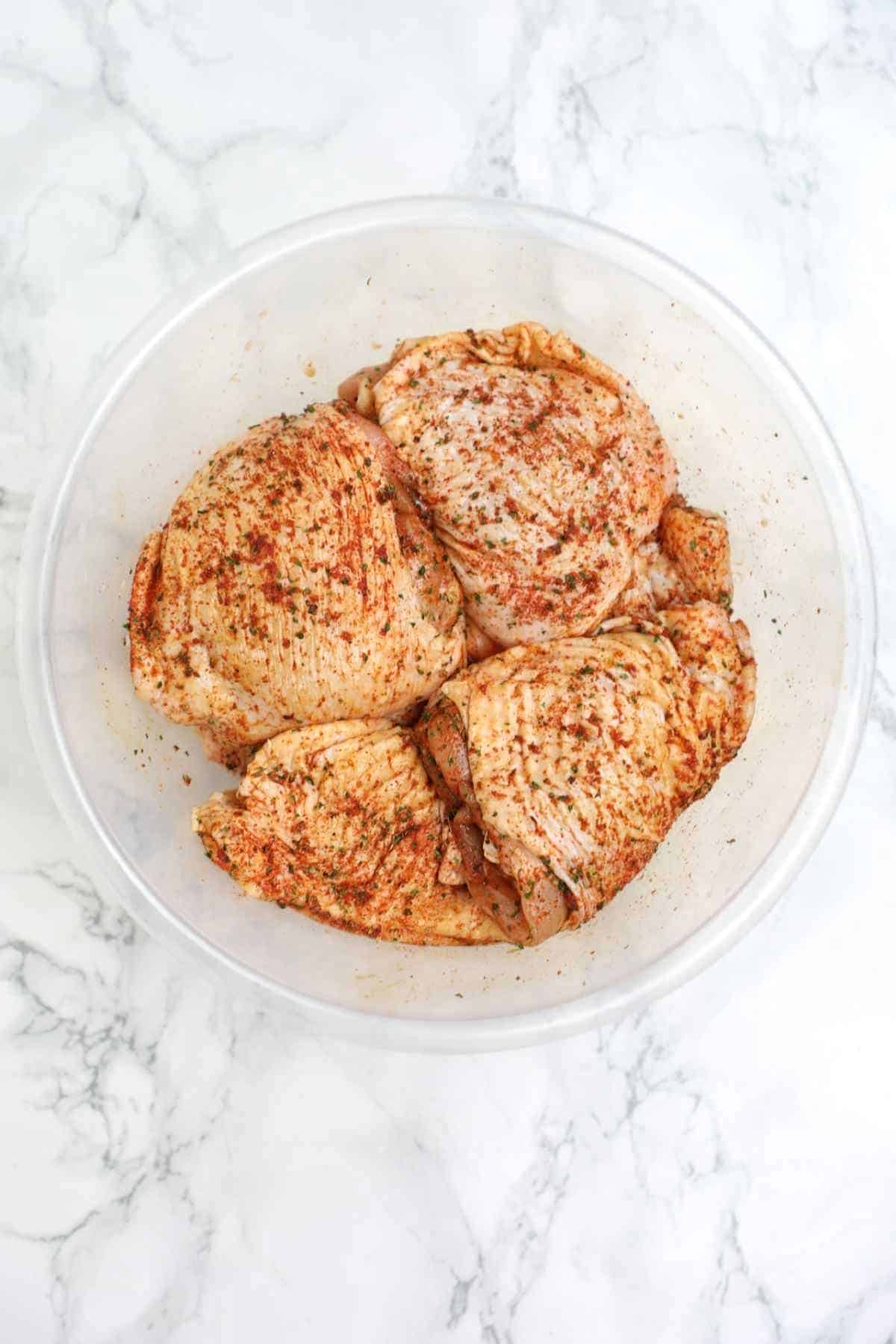 seasoned chicken thighs in a bowl.