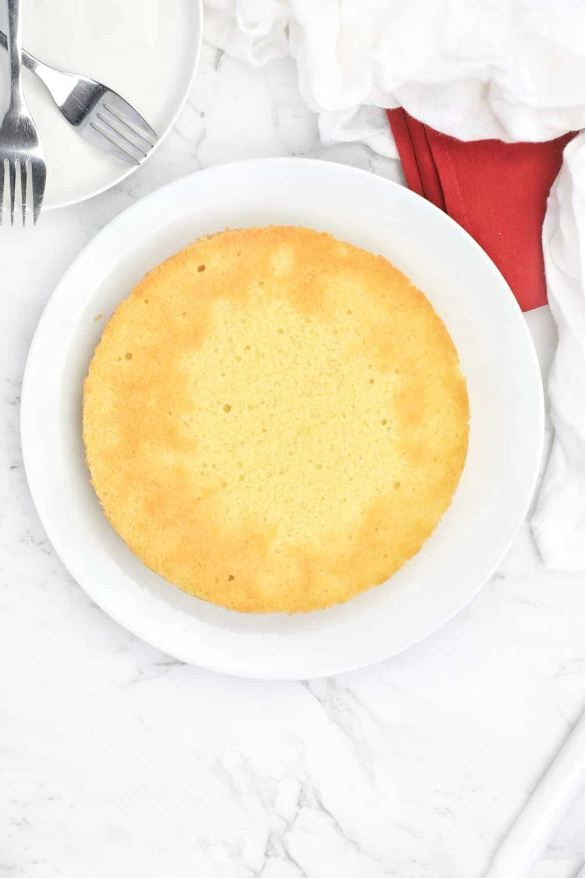 round sponge cake on a white plate.