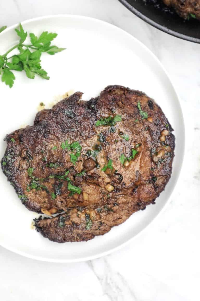 pan fried steak served on a white plate.