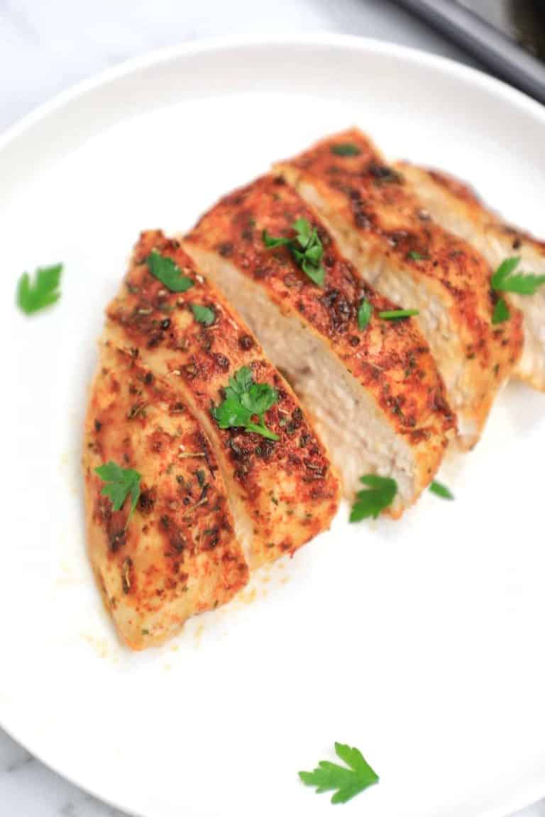 cooked chicken breast served and sliced on a plate.