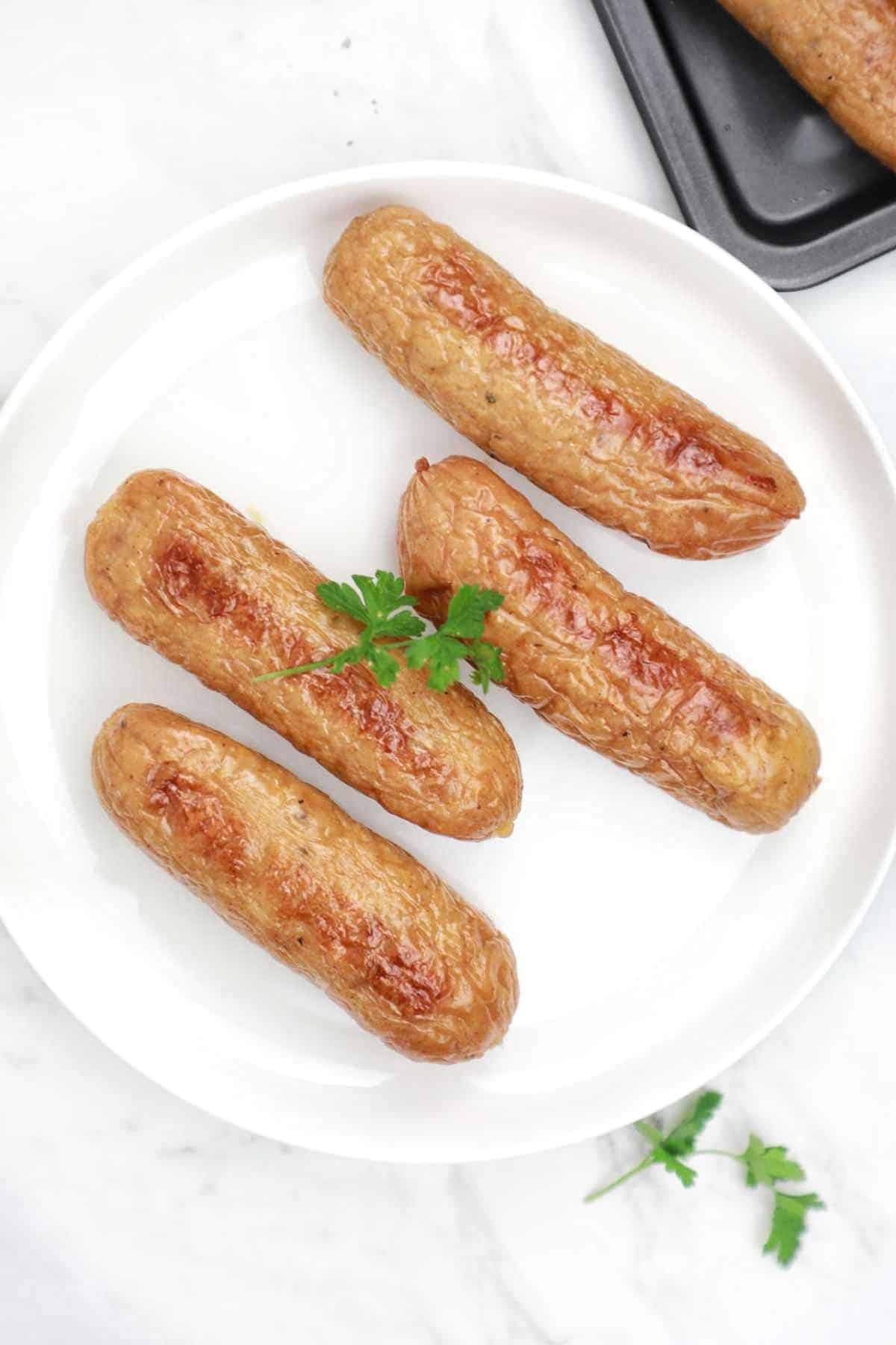 baked sausages on a white plate.