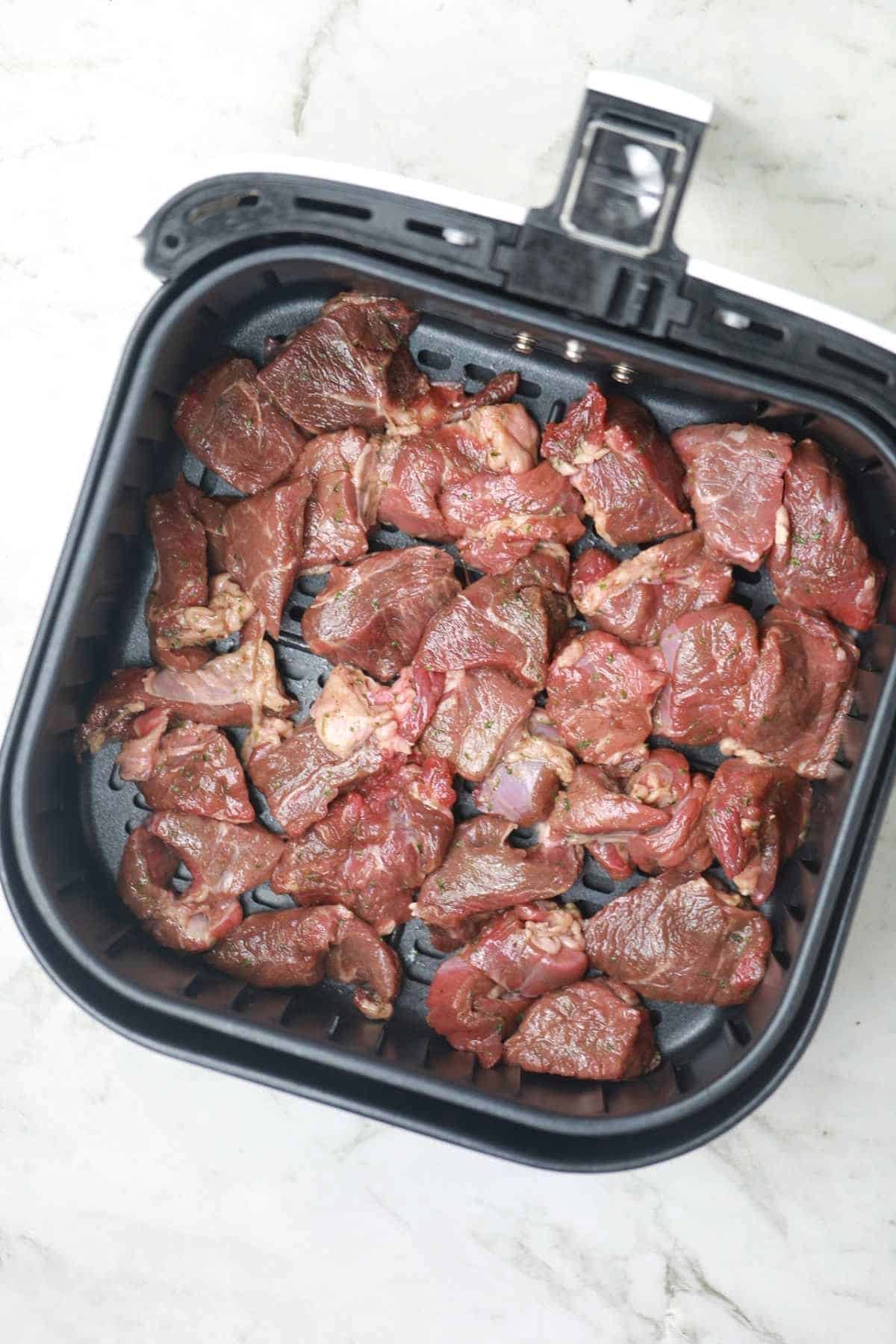 steak bites arranged in air fryer.