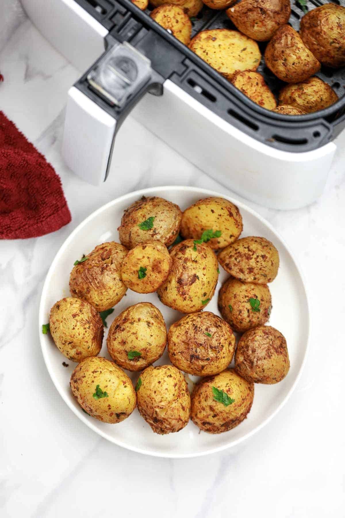 baby potatoes in air fryer and on a white plate.