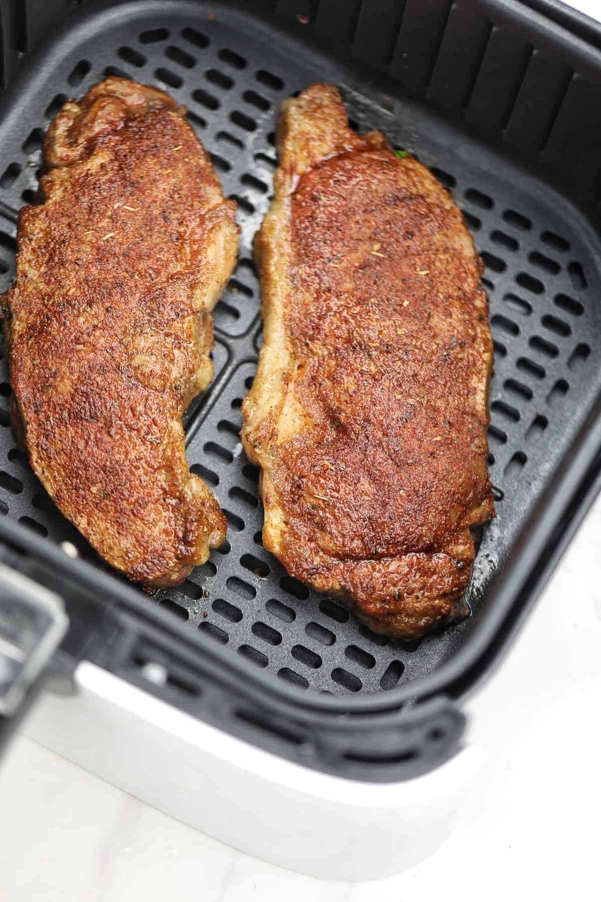 2 cooked sirloin steak in air fryer.