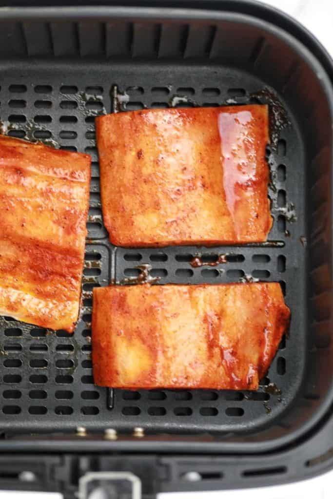 the marinated fillets arranged in the air fryer basket.