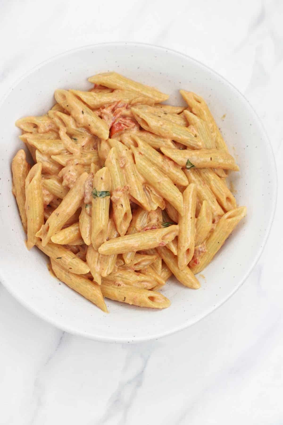 creamy tomato pasta served in a white plate.