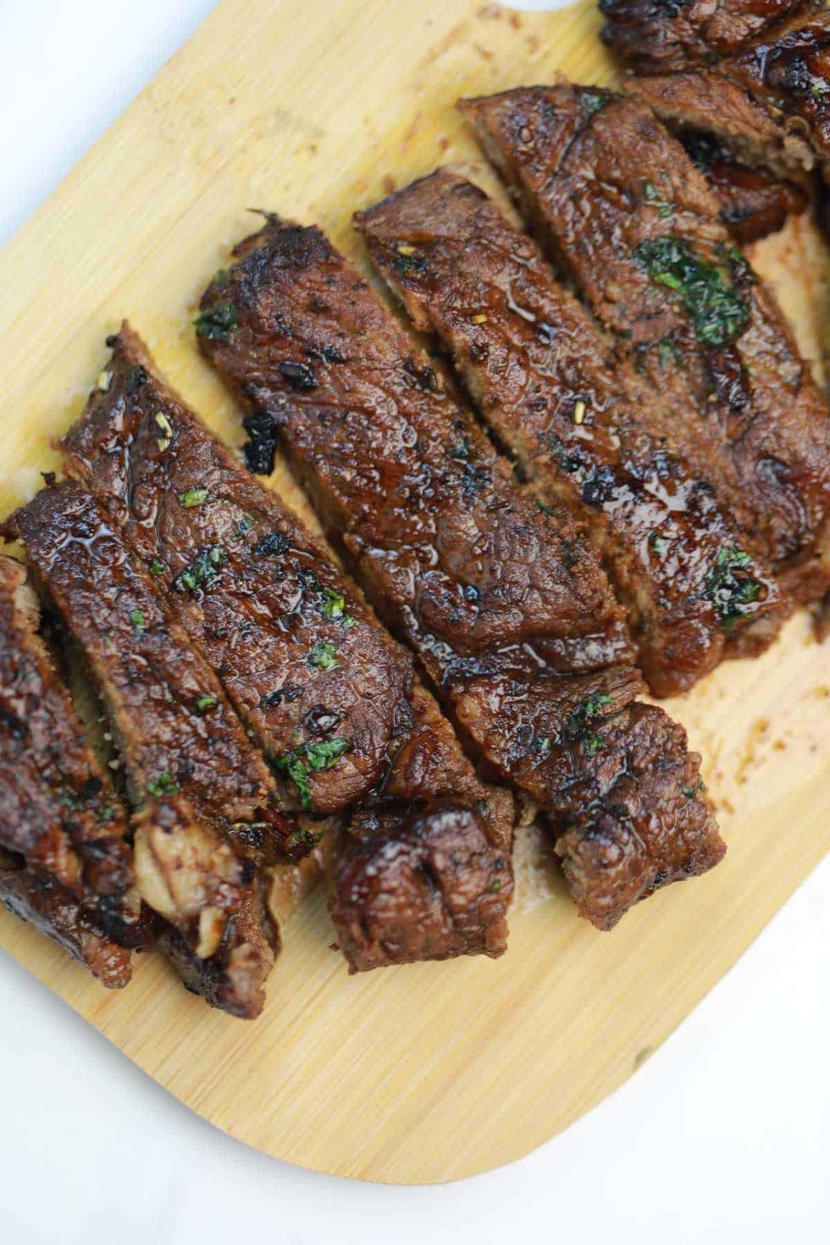 cooked sirloin steak cut on a serving board.