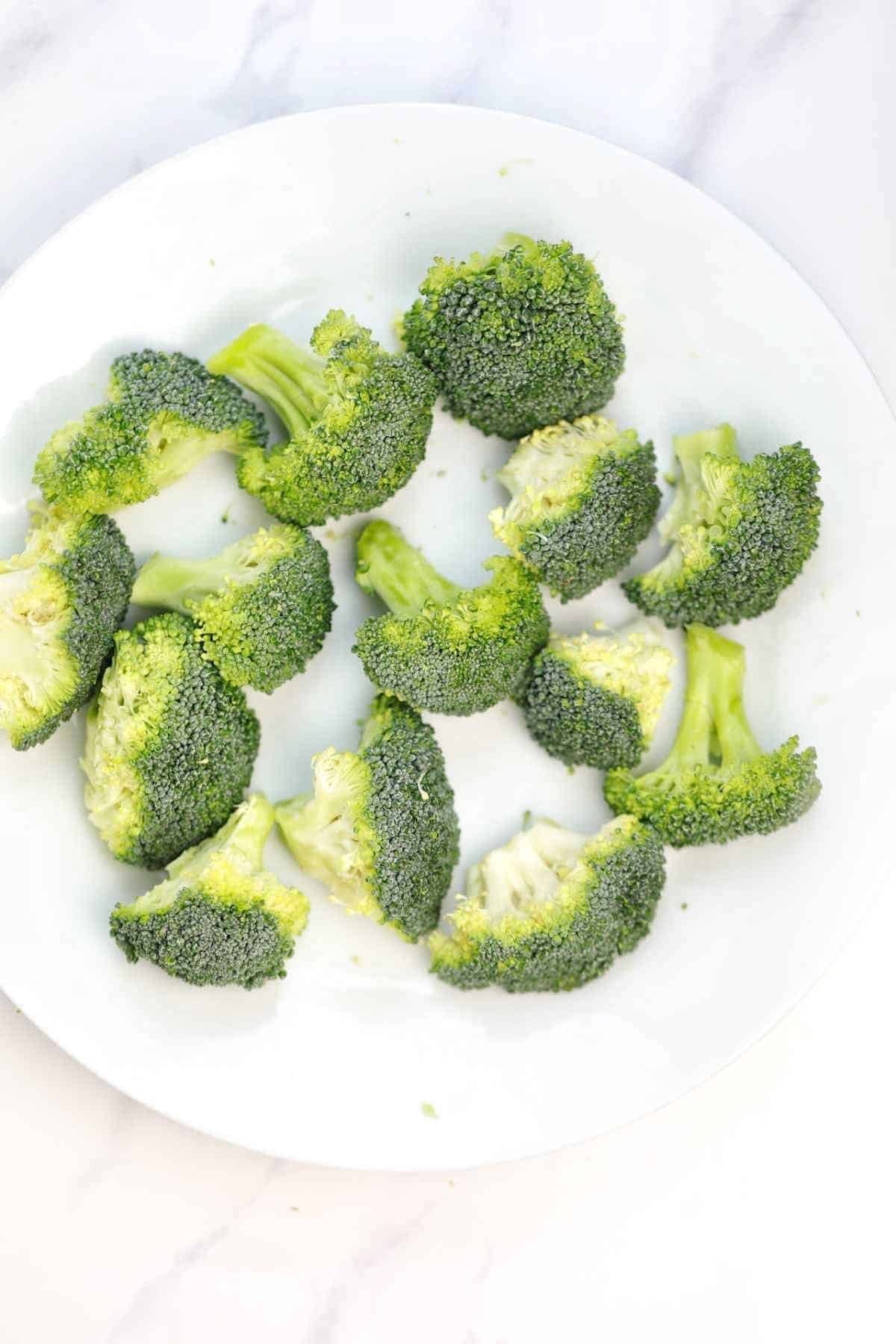 broccoli florets on a white plate.
