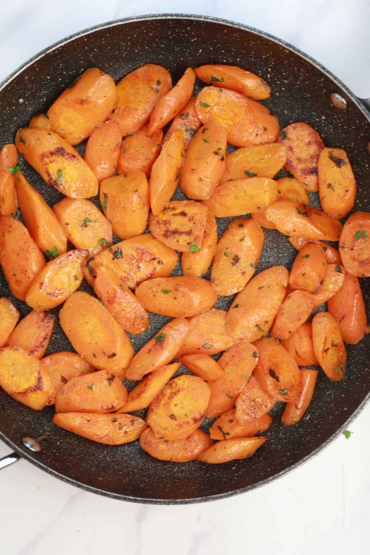 pan fried carrots in a skillet.