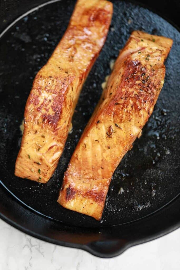 pan fried salmon fillets in a pan.