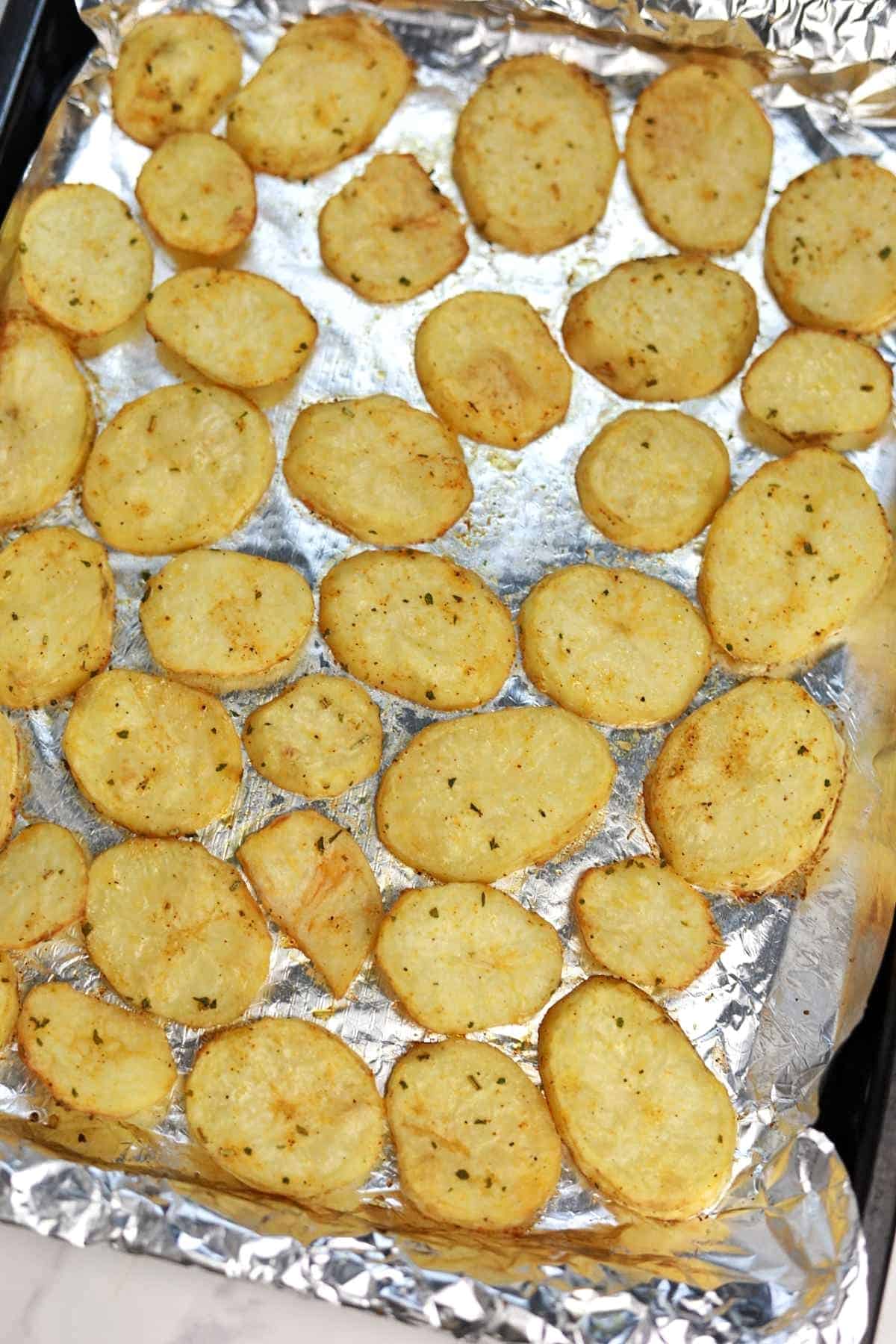 baked sliced potatoes on a baking tray.