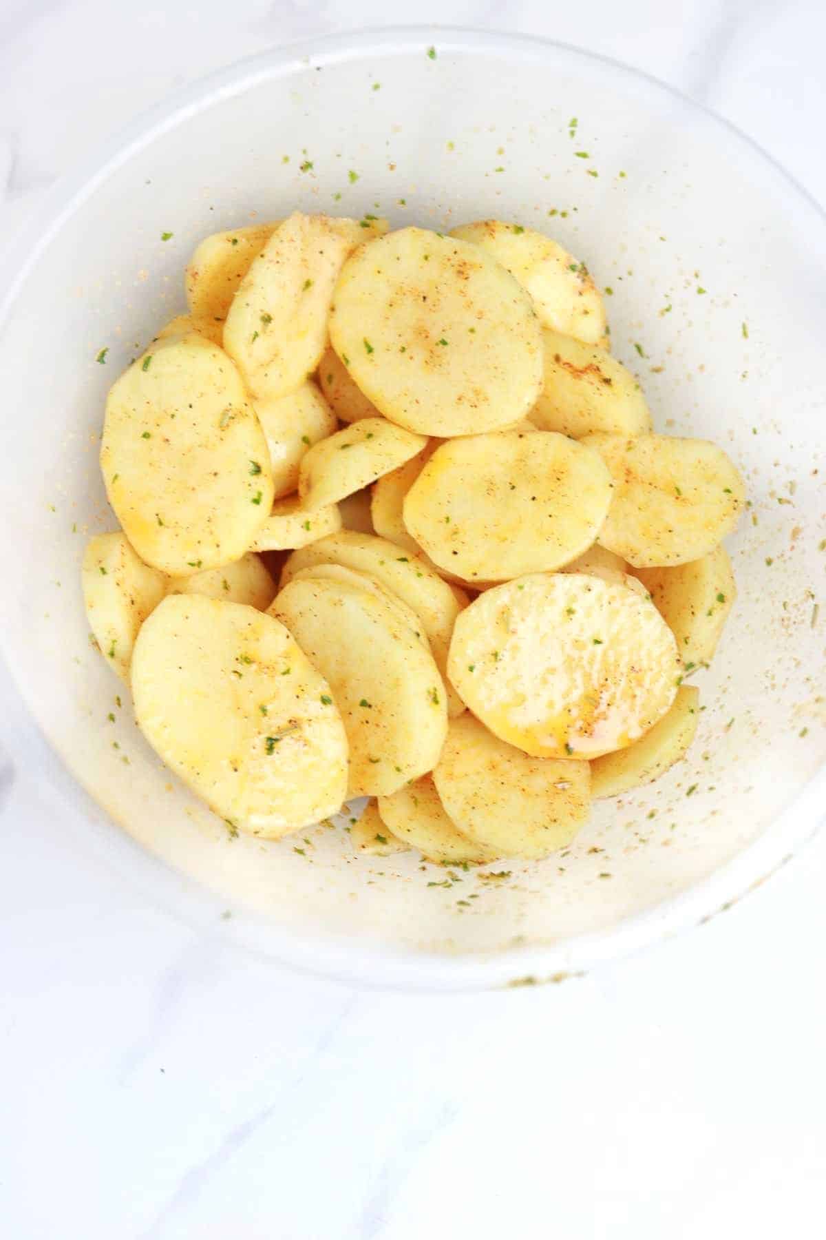 seasoned sliced potatoes in a bowl.