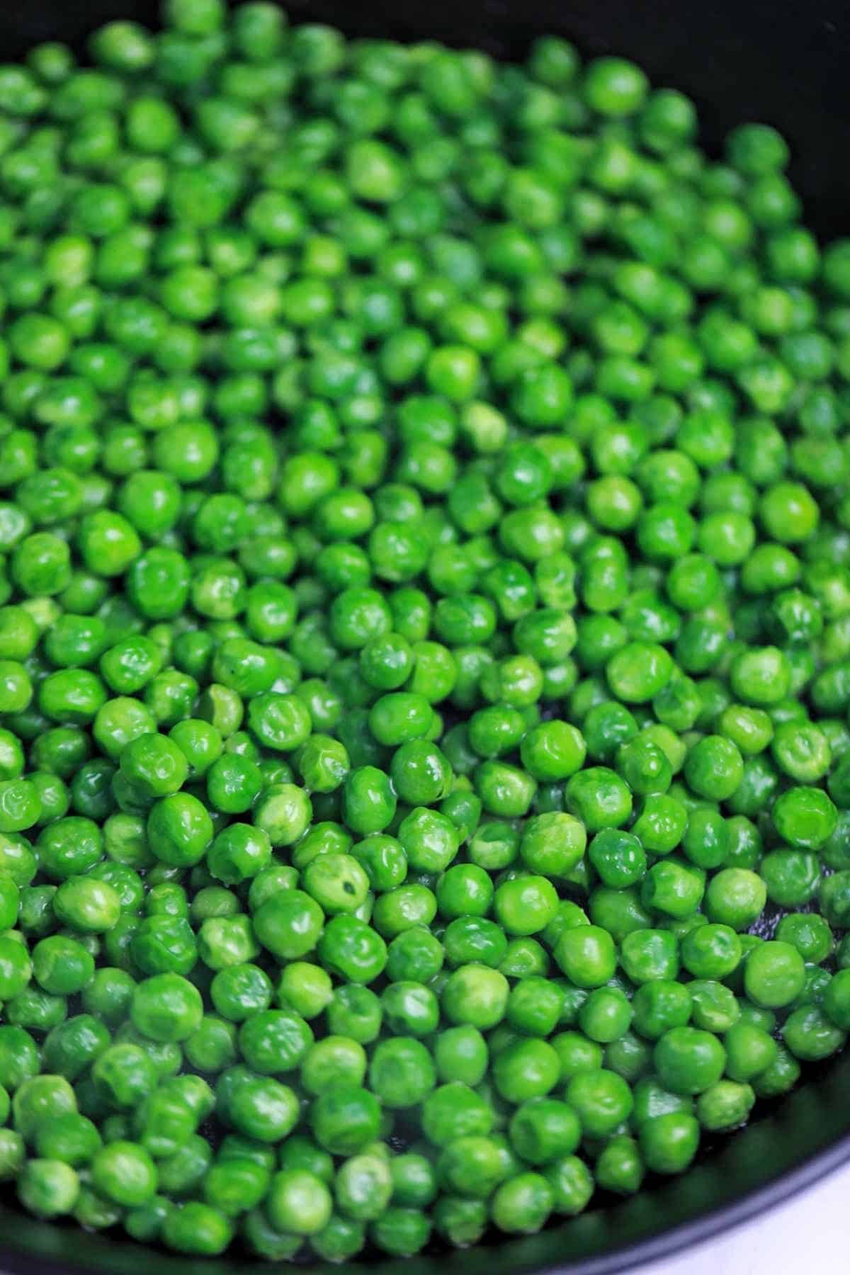 cooked green peas in a skillet.