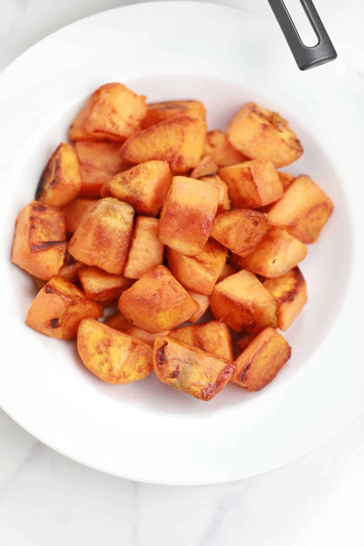 fried sweet potatoes served on a white plate.