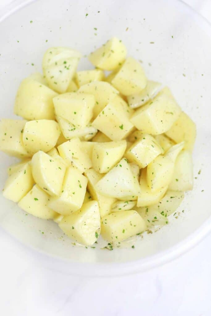 seasoned potatoes and onions in a bowl.