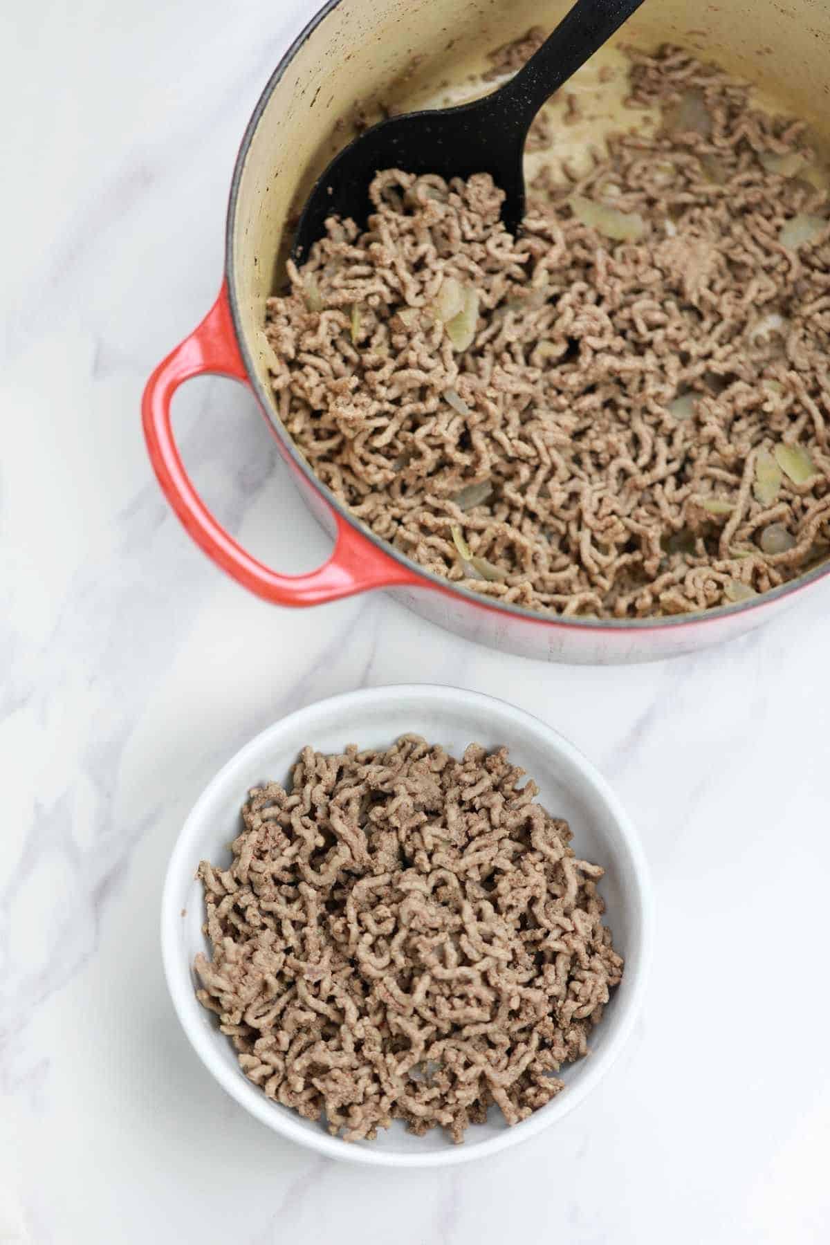 boiled ground beef in a red pot and white plate.