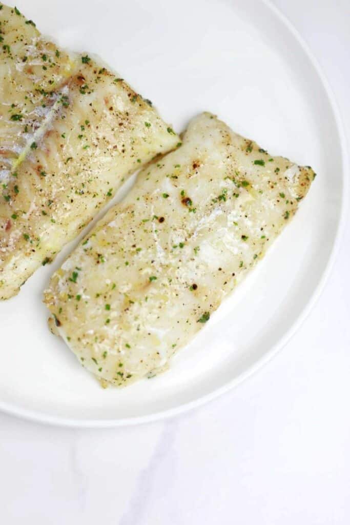 air fryer frozen cod served on a white plate.