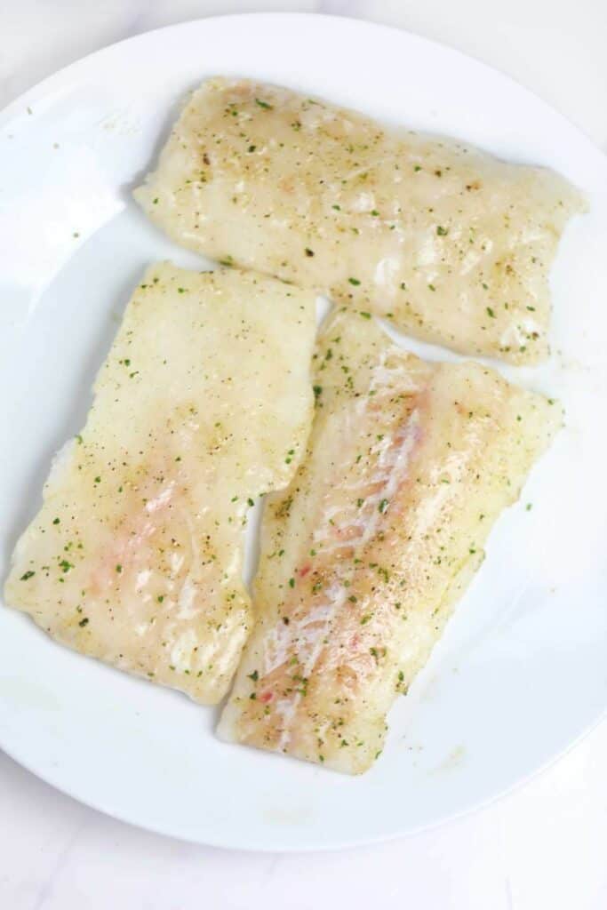 season cod fillets on a white plate.