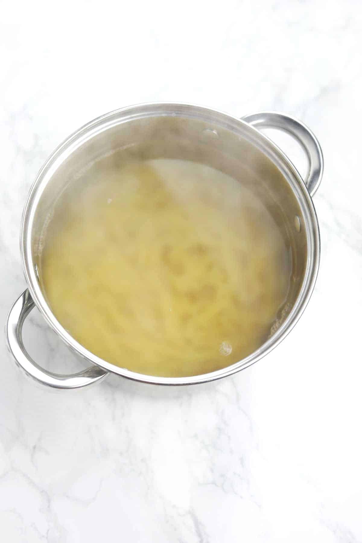 boiling water, salt and pasta in a pot.