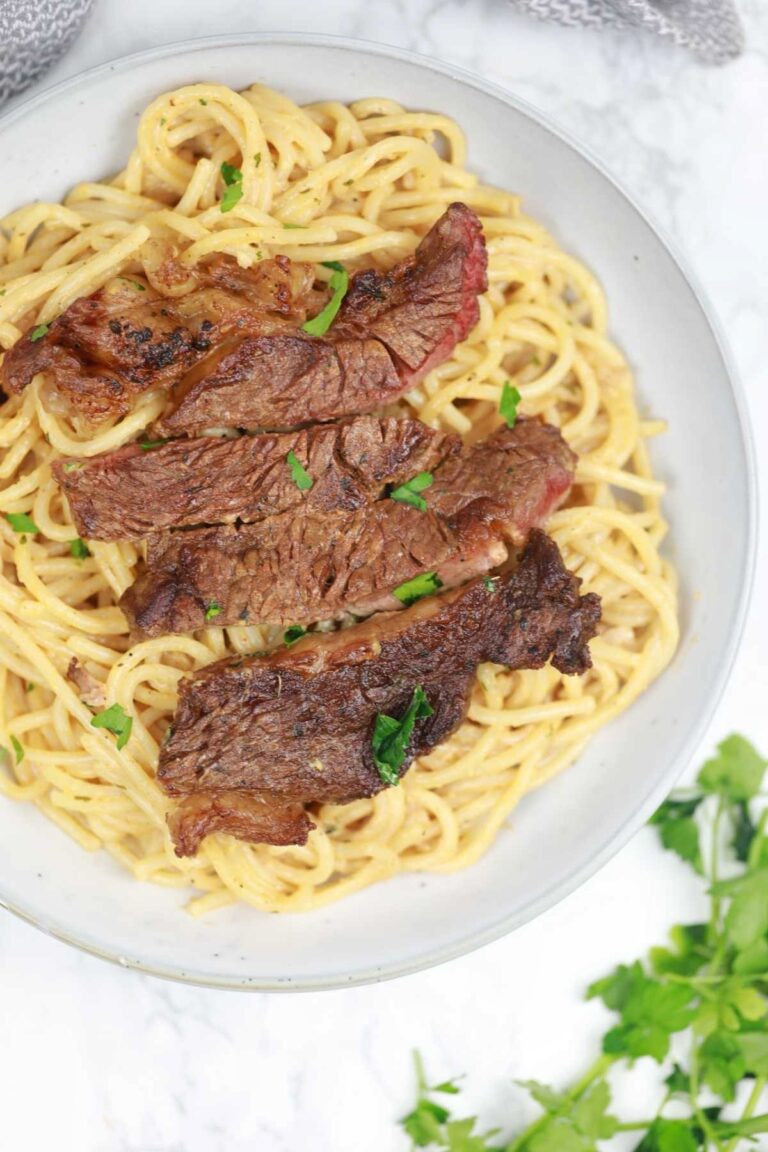steak pasta served on a plate.