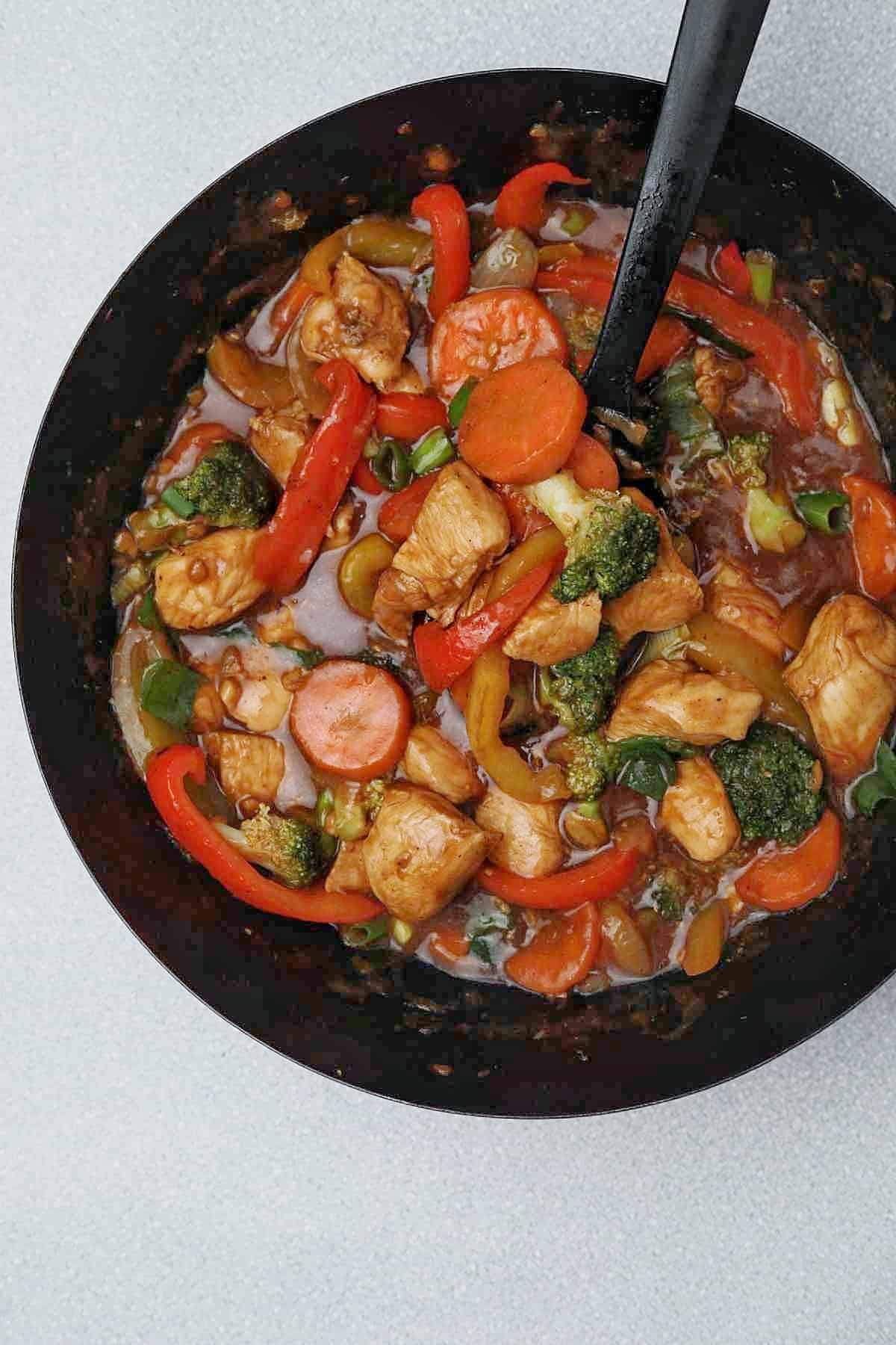 Chinese chicken stir fry and vegetables  in a wok.