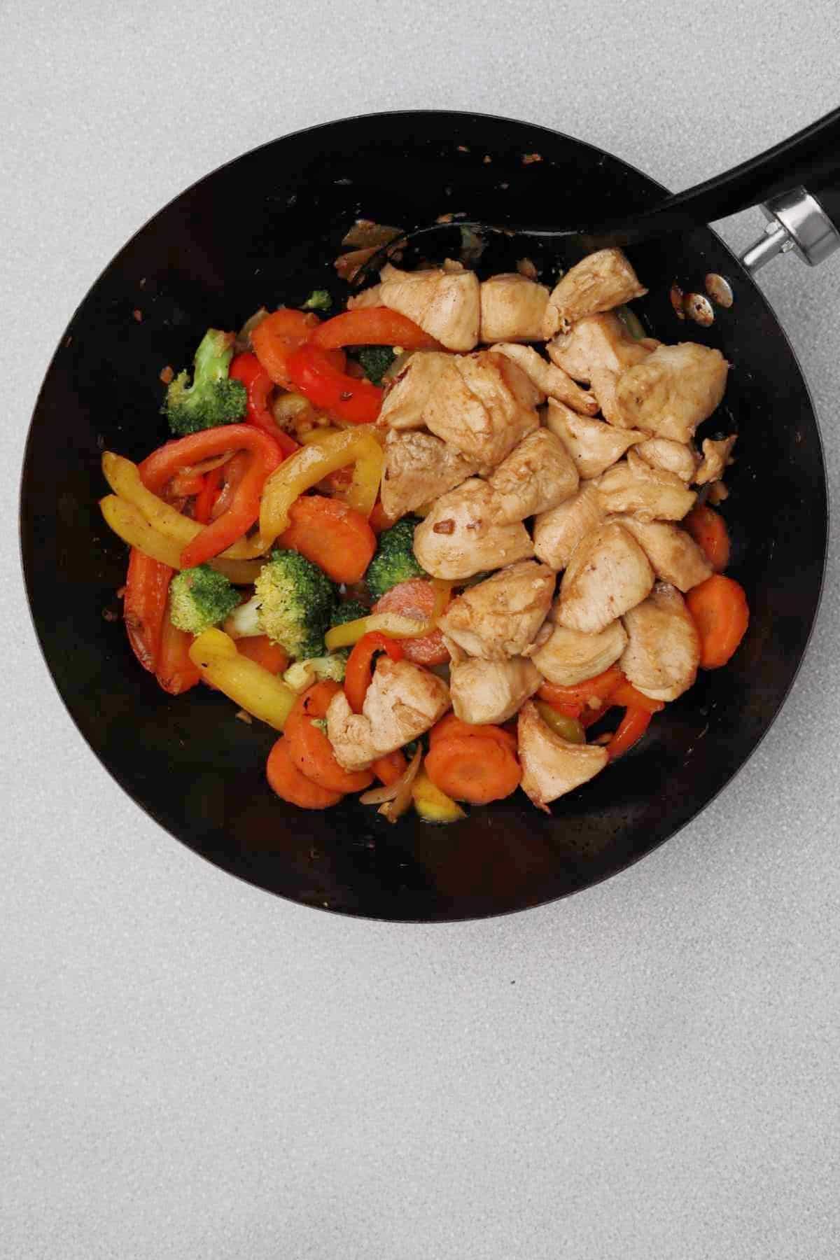 chicken and vegetables in a wok.