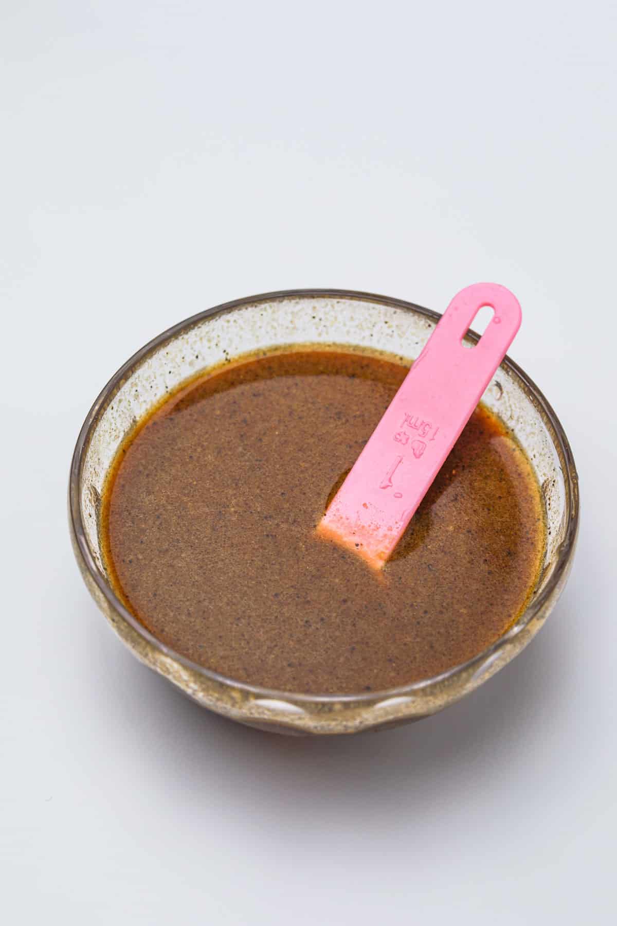 stir fry sauce in a bowl with pink spoon.