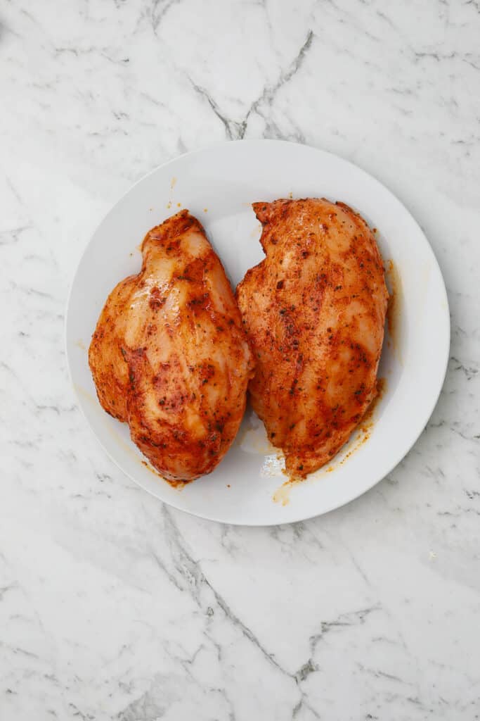 seasoned frozen chicken breasts on a plate.