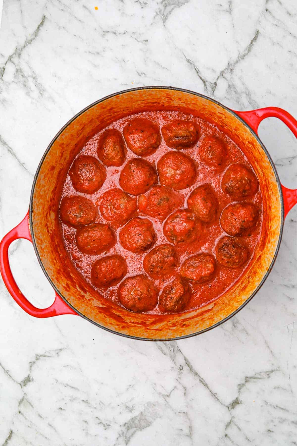 meatballs added to the sauce in the pot.