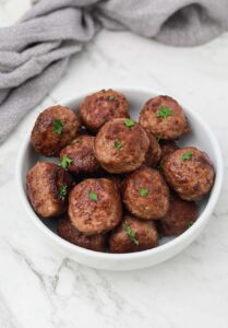 pan fried meatballs garnished with parsley.