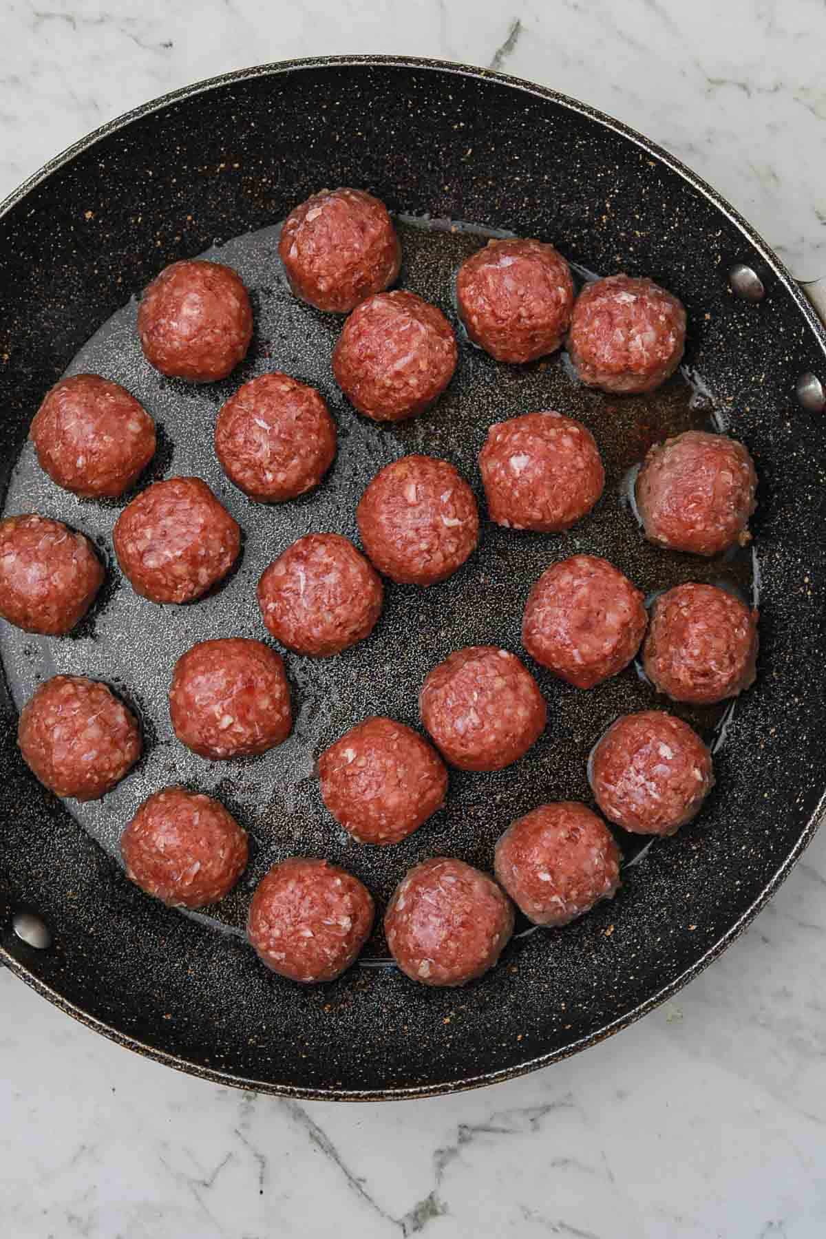meatballs arranged in a skillet.