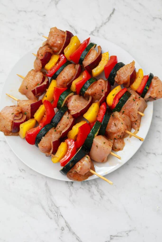 marinated chicken kabobs on a white plate.