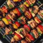 cooked marinated chicken kabobs in a grill pan.