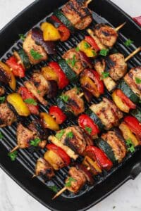 cooked marinated chicken kabobs in a grill pan.
