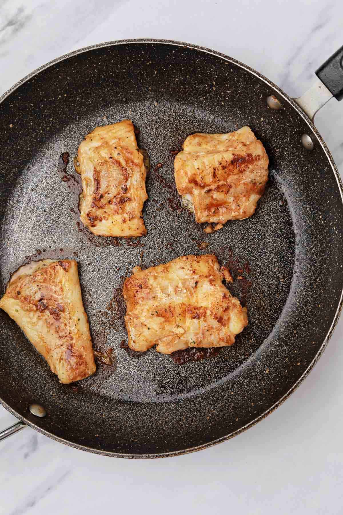 4 fish fillets in a pan