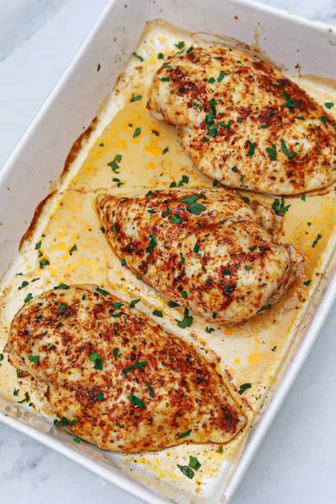 baked chicken breast in a white baking dish.