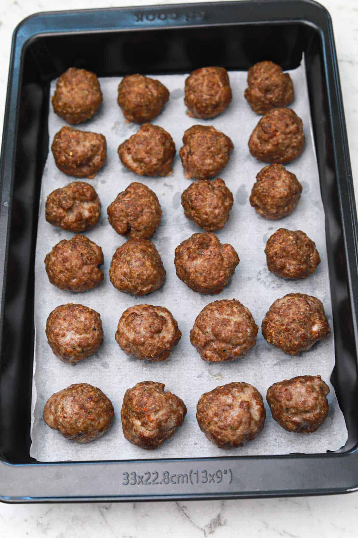 oven baked meatballs on a baking tray.