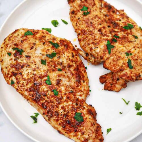 air fryer thin chicken breasts served and garnished with parsley.