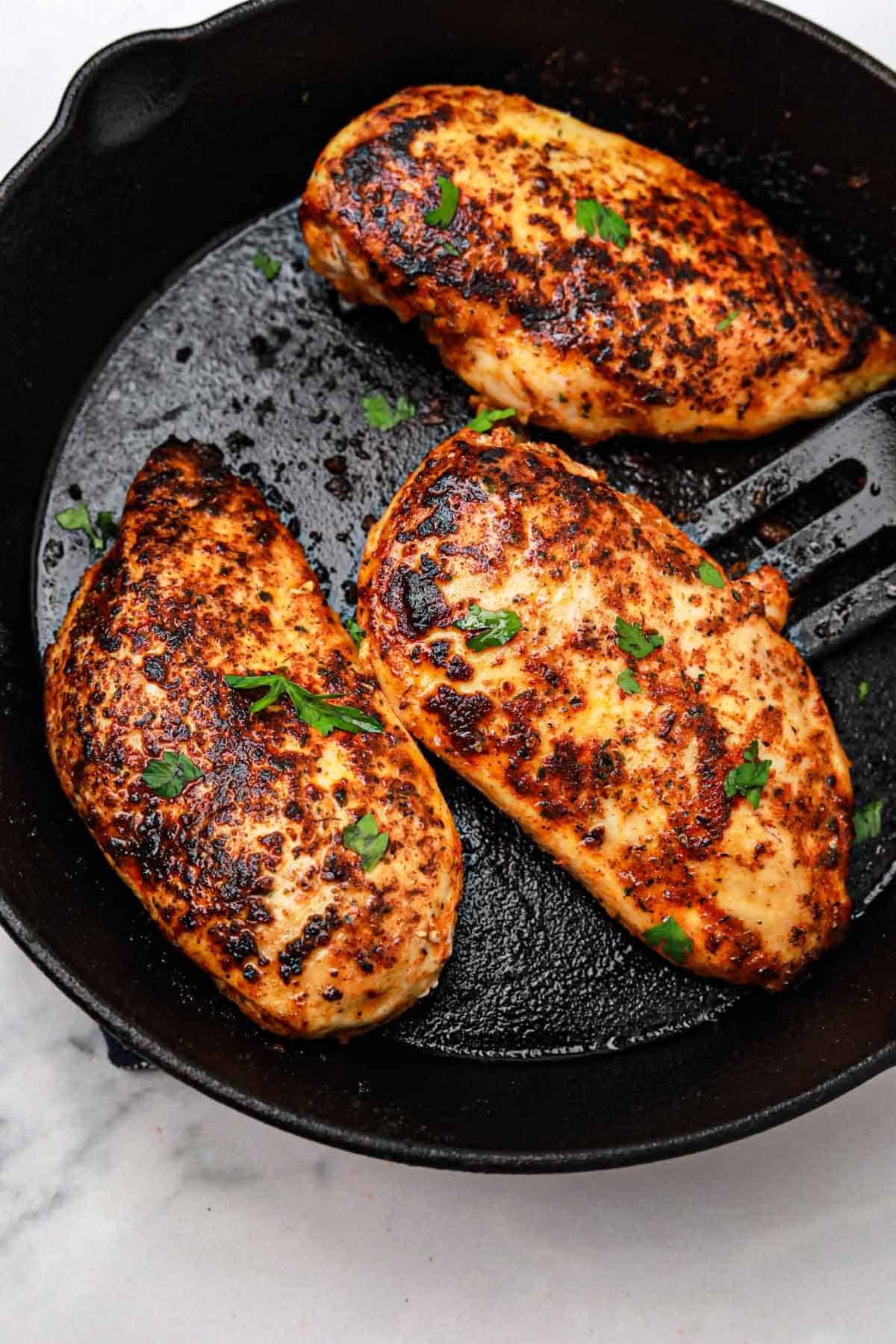 3 juicy chicken breasts in a skillet.