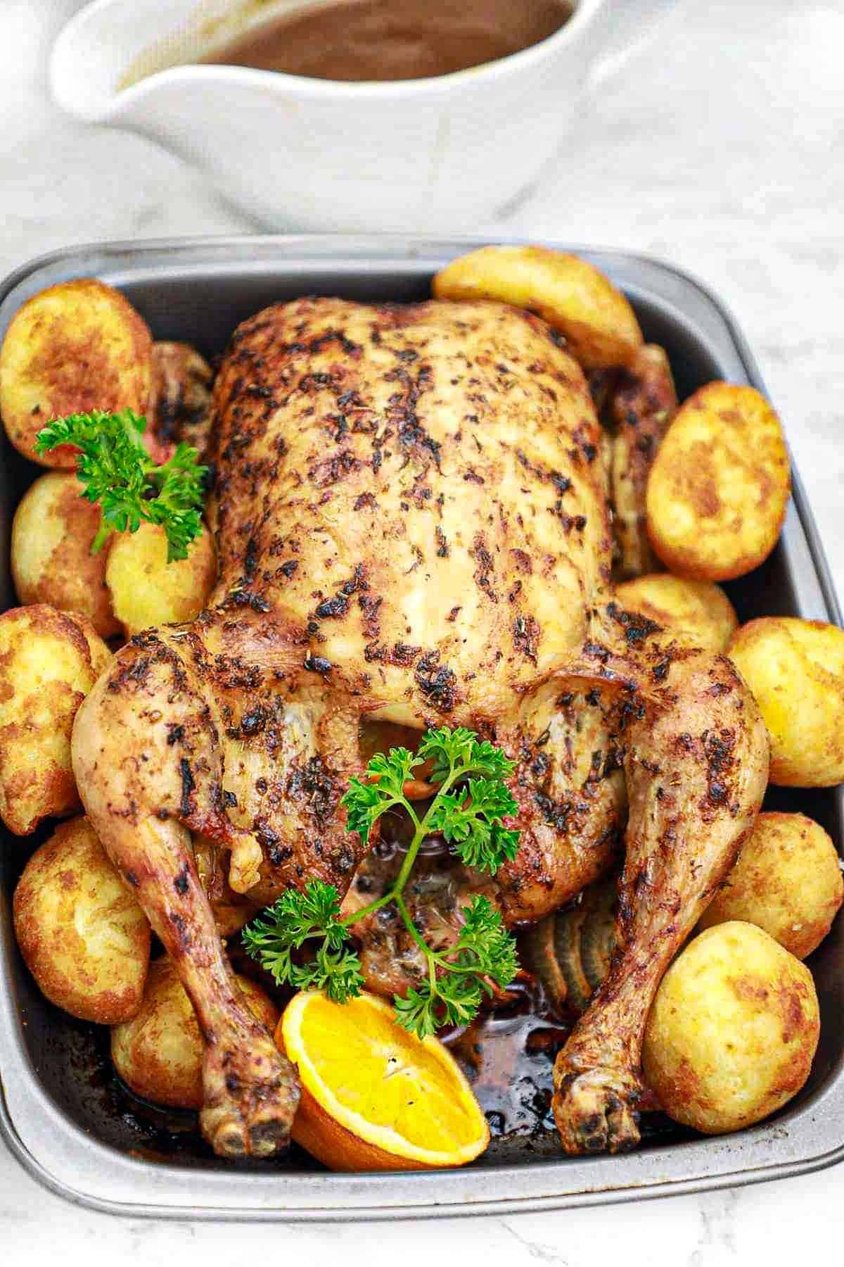 Christmas roast chicken on a tray with potatoes.