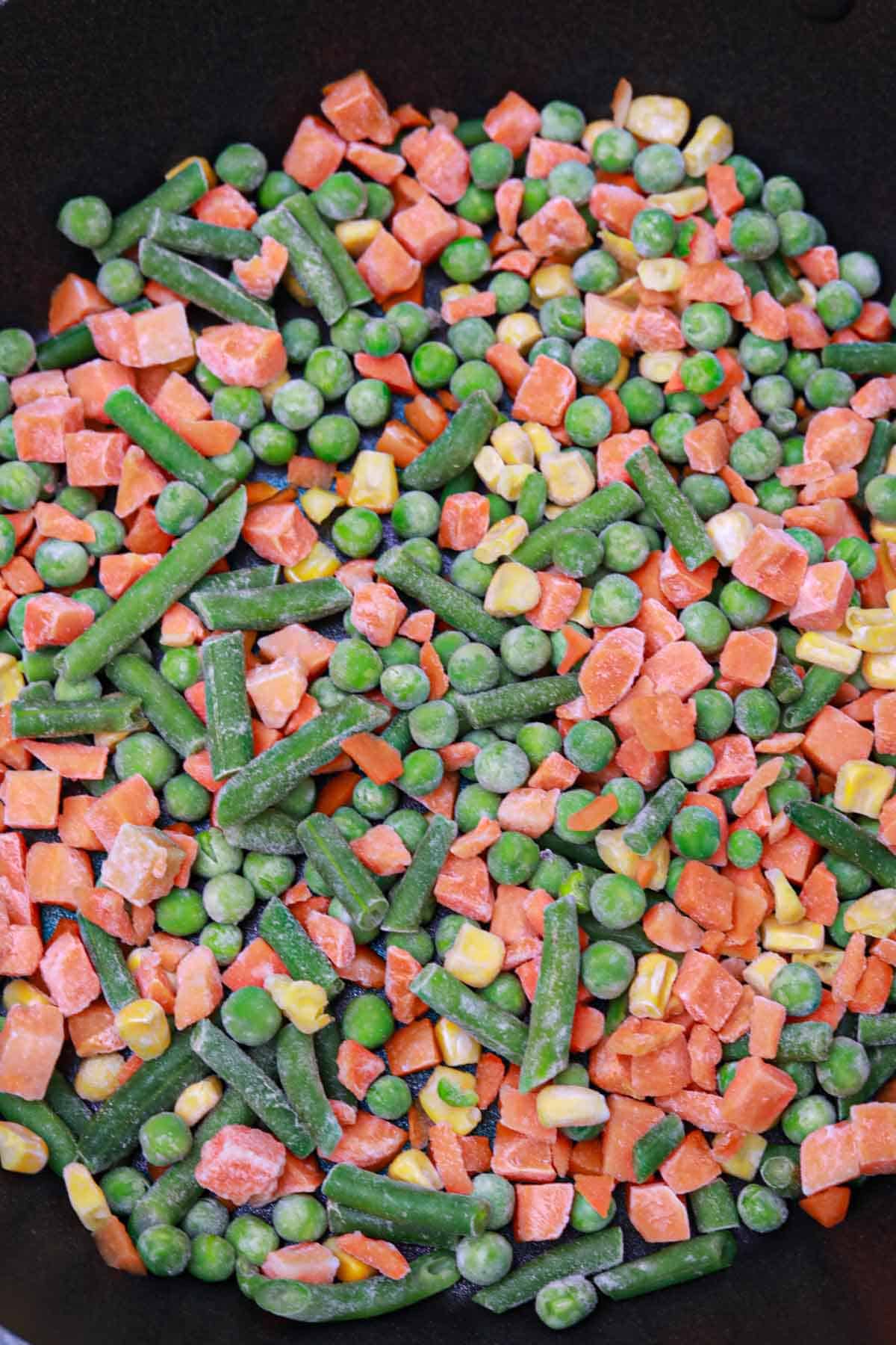 frozen mixed vegetables in a skillet.