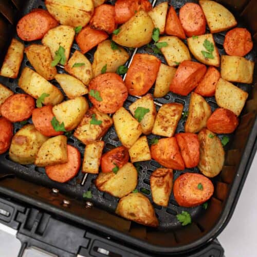carrots and potatoes in air fryer basket.