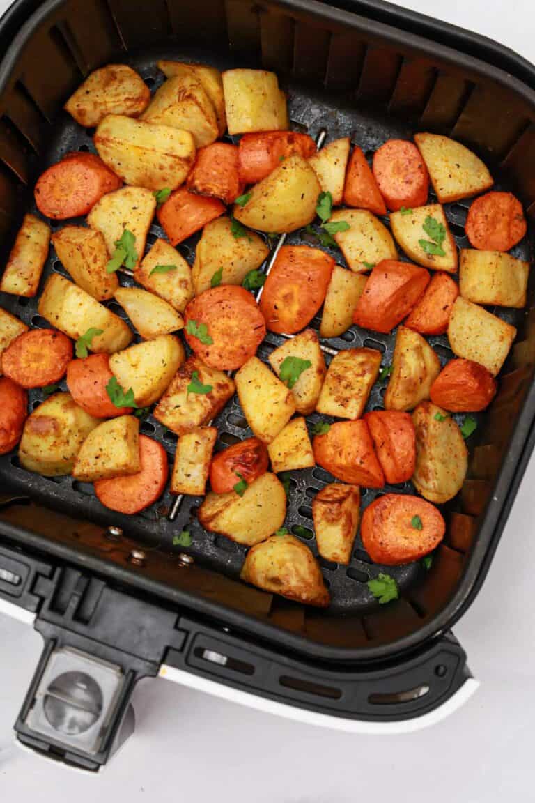 carrots and potatoes in air fryer basket.