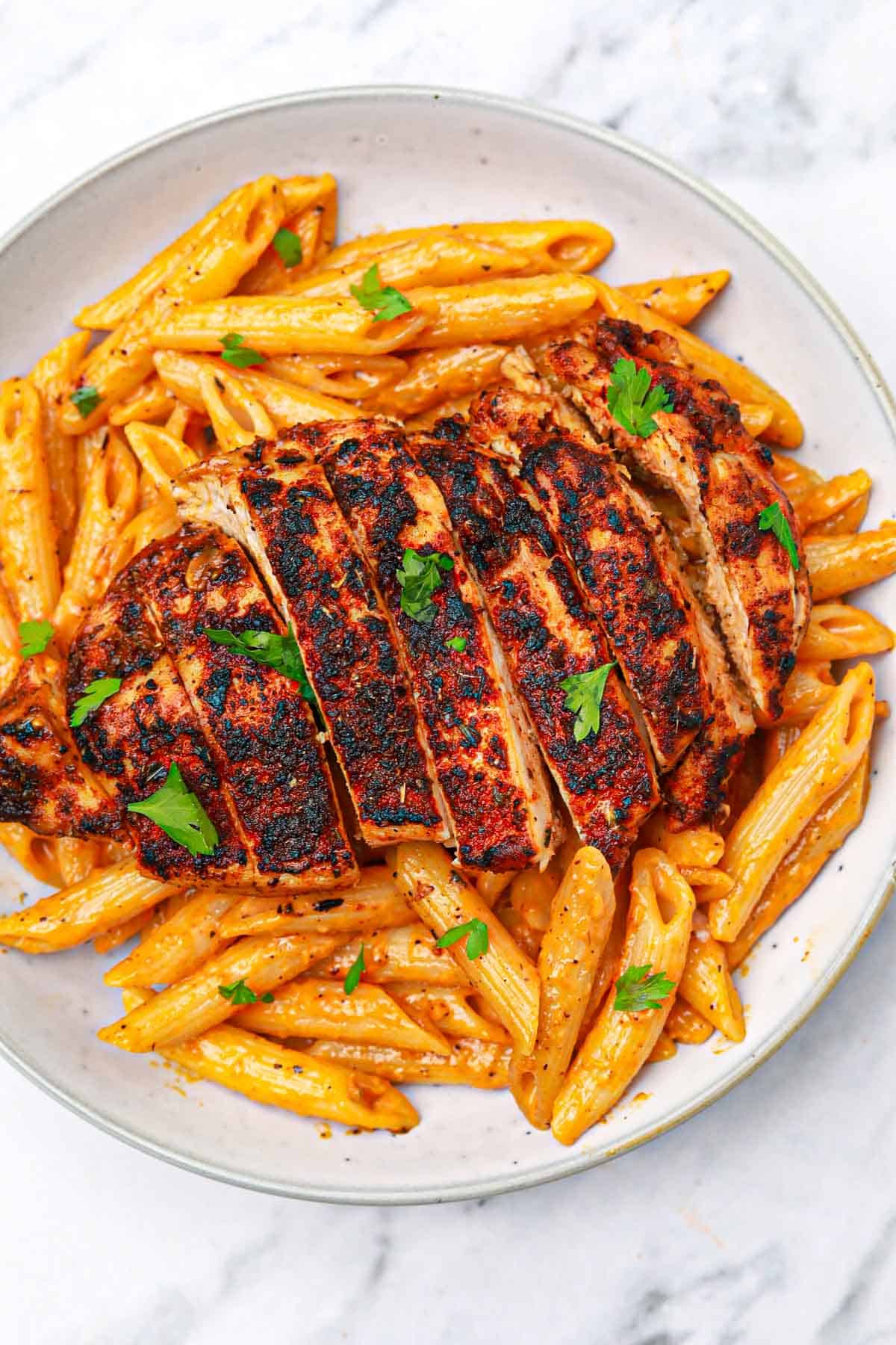 blackened chicken and pasta on a plate.