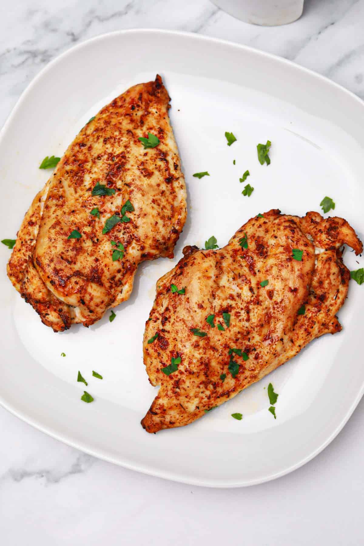 air fryer boneless skinless chicken breasts served on a plate.